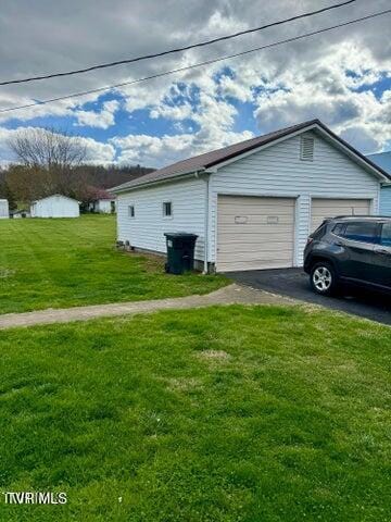 view of home's exterior featuring a garage and a lawn