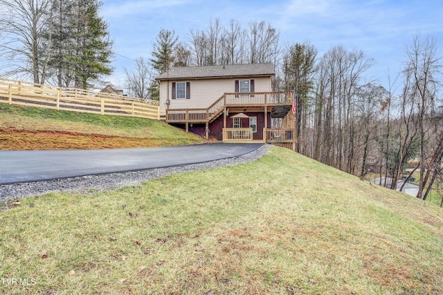 rear view of house with a yard and a deck