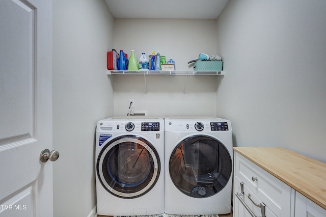 clothes washing area featuring cabinets and washing machine and dryer