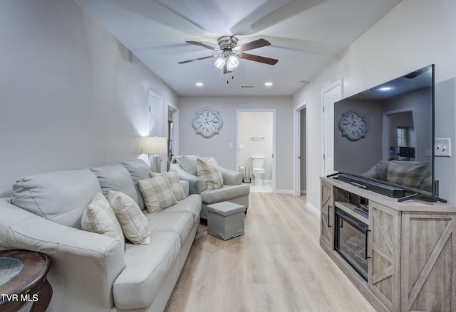 living room featuring ceiling fan and light wood-type flooring