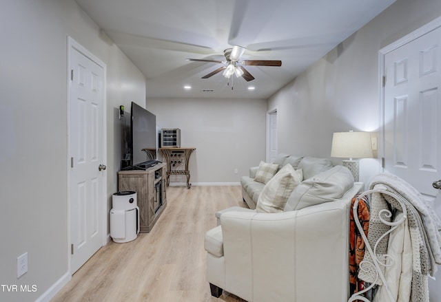 living room featuring ceiling fan and light hardwood / wood-style floors