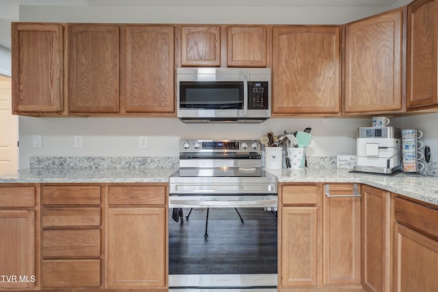 kitchen featuring stainless steel appliances and light stone counters