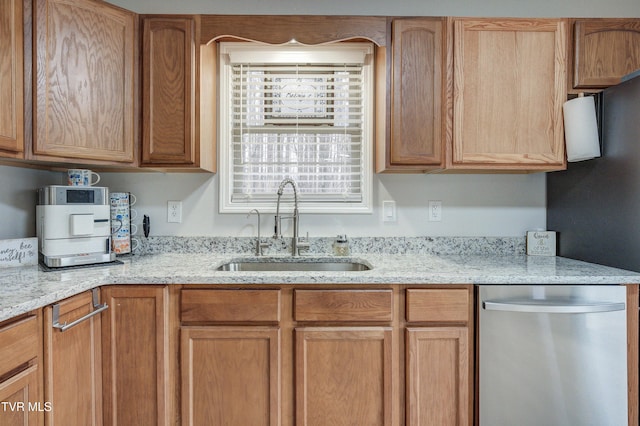 kitchen with stainless steel dishwasher, light stone countertops, and sink