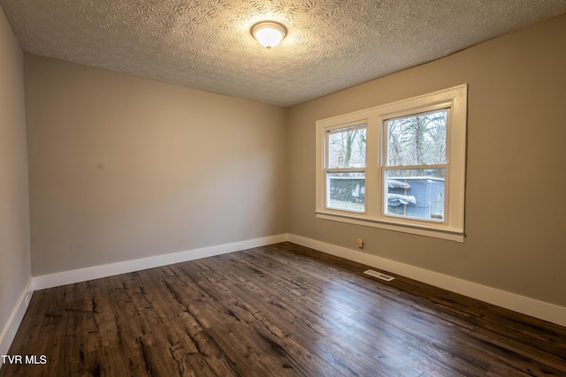 unfurnished room featuring dark hardwood / wood-style floors and a textured ceiling