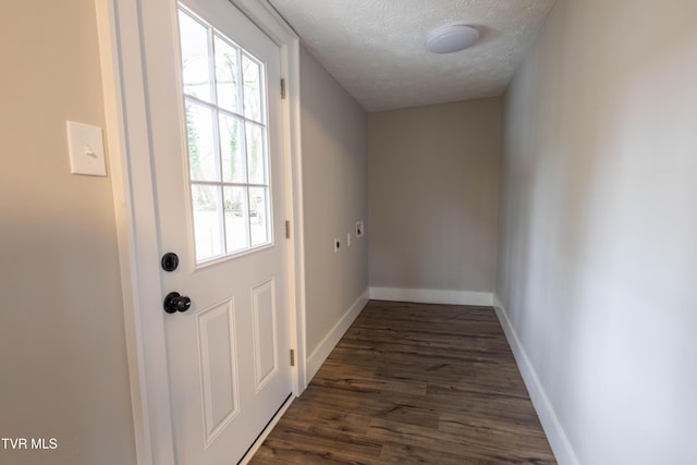 doorway to outside with dark wood-type flooring and a textured ceiling