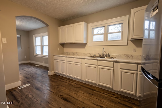 kitchen featuring white cabinetry, sink, dark wood-type flooring, and stainless steel fridge