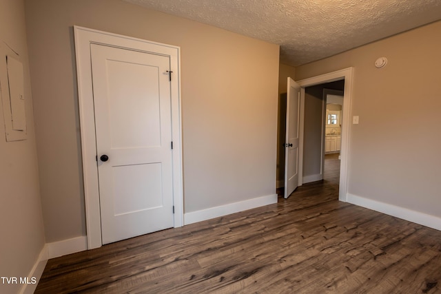 spare room with dark hardwood / wood-style floors and a textured ceiling