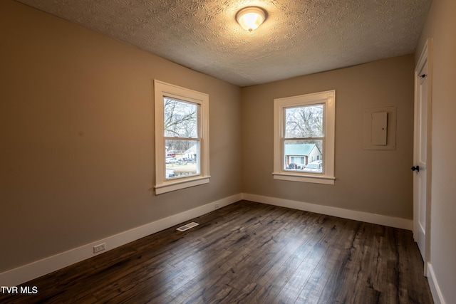 empty room featuring dark hardwood / wood-style flooring and a textured ceiling