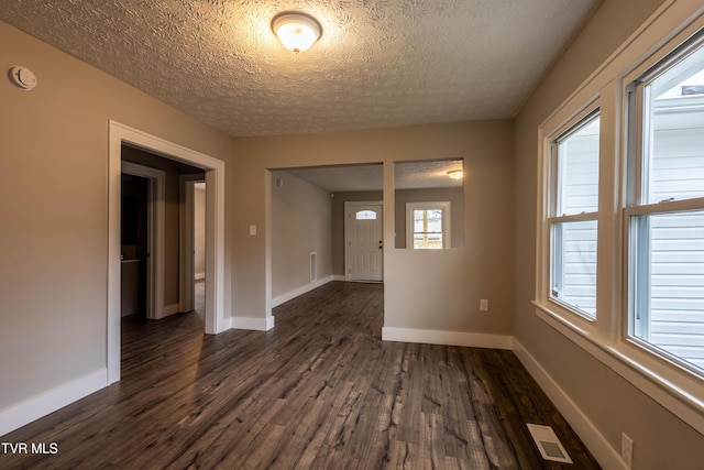 empty room featuring dark hardwood / wood-style floors and a textured ceiling