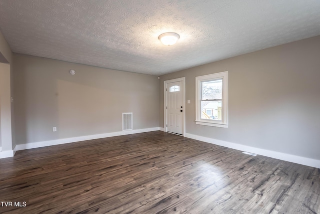 foyer with dark wood-type flooring and a textured ceiling