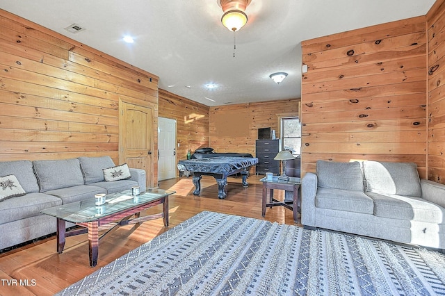 living room with wood finished floors, visible vents, wood walls, and pool table