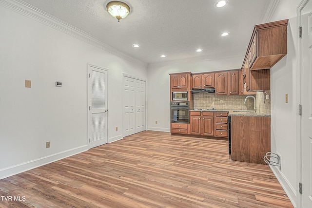 kitchen featuring black oven, light hardwood / wood-style flooring, stainless steel microwave, light stone counters, and exhaust hood