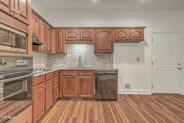 kitchen featuring ventilation hood, sink, light hardwood / wood-style floors, black appliances, and light stone countertops