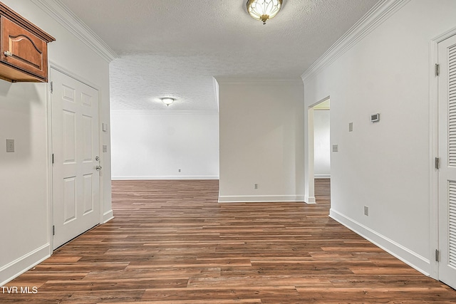 empty room with crown molding, dark hardwood / wood-style flooring, and a textured ceiling