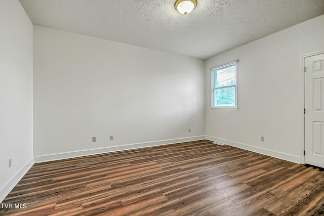 unfurnished room with dark wood-type flooring and a textured ceiling