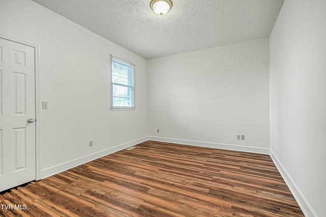 empty room featuring dark wood-type flooring and a textured ceiling