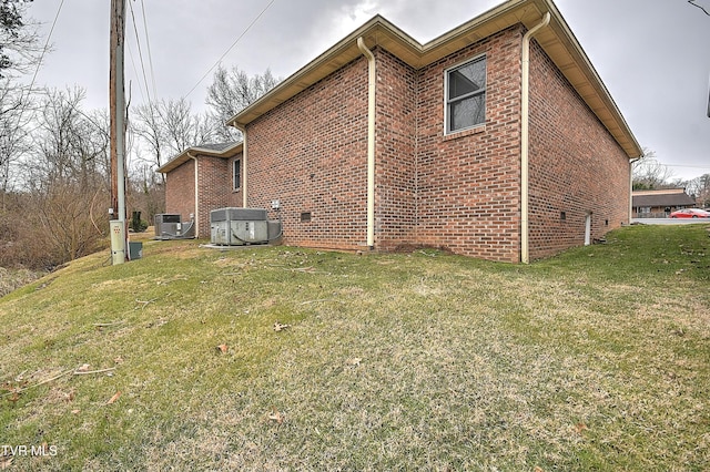 view of side of home with cooling unit and a lawn