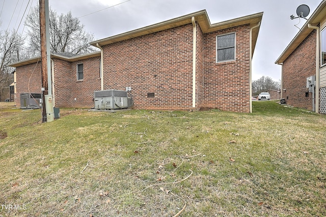 view of side of home featuring cooling unit and a lawn