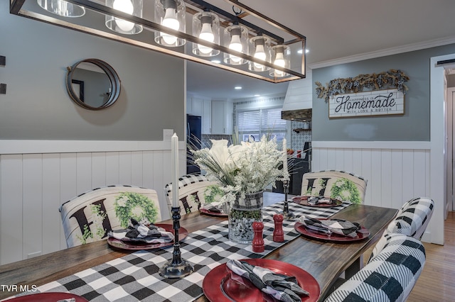 dining space featuring ornamental molding and light hardwood / wood-style flooring