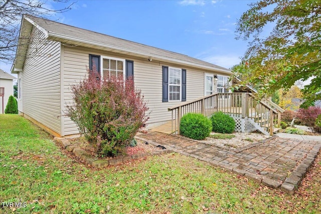 view of side of home with a lawn and a deck