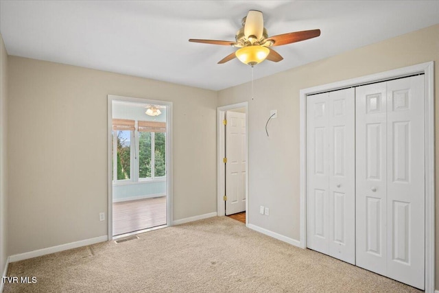 unfurnished bedroom featuring light carpet, ceiling fan, and a closet