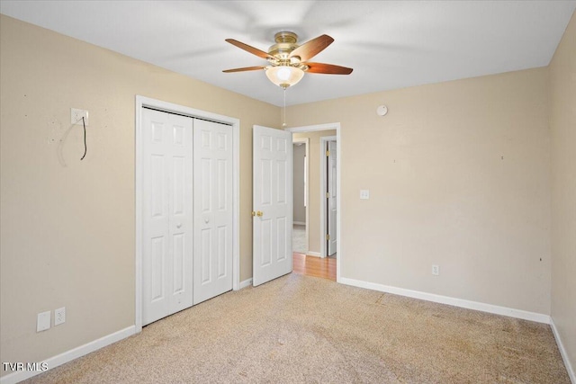 unfurnished bedroom with light colored carpet, a closet, and ceiling fan