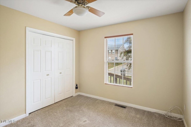 unfurnished bedroom with carpet floors, a closet, and ceiling fan