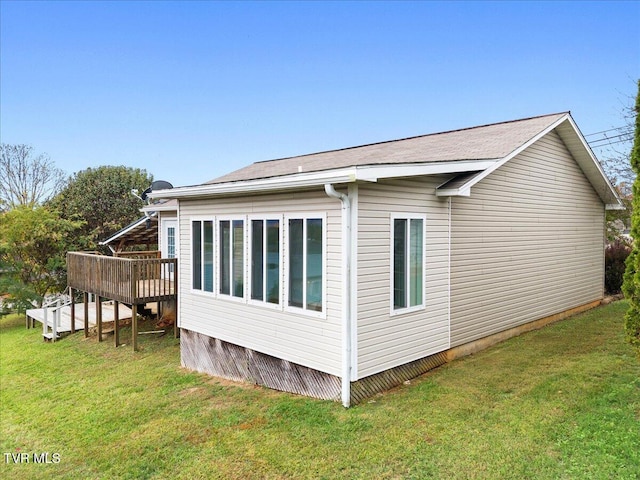 view of side of home featuring a wooden deck and a yard