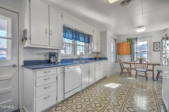 kitchen featuring white dishwasher, sink, and white cabinets