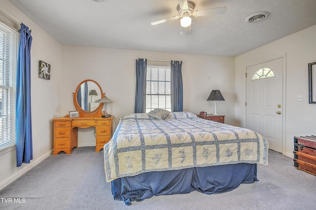 carpeted bedroom with multiple windows, a textured ceiling, and ceiling fan