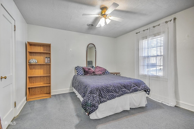 bedroom featuring ceiling fan, a textured ceiling, and dark colored carpet