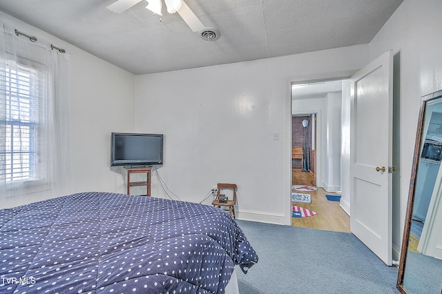 bedroom featuring ceiling fan, carpet flooring, and a textured ceiling