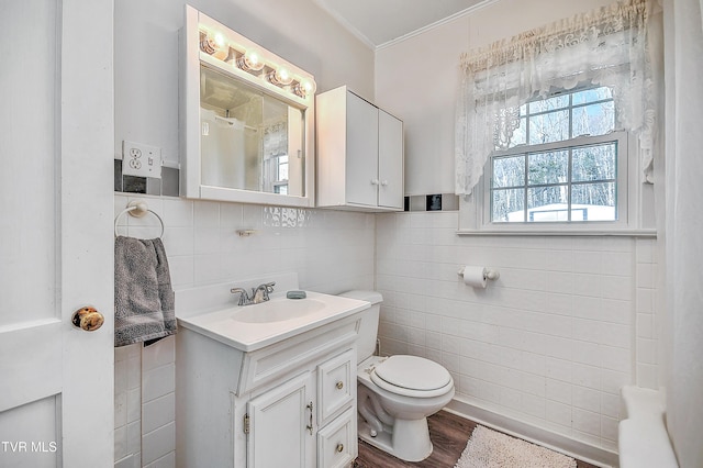 bathroom featuring hardwood / wood-style floors, vanity, tile walls, and toilet