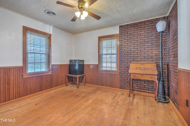 sitting room featuring light hardwood / wood-style floors, a textured ceiling, and a wealth of natural light