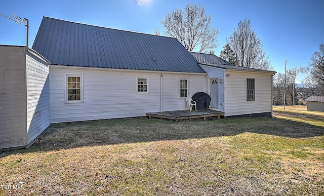 rear view of house featuring a deck and a lawn