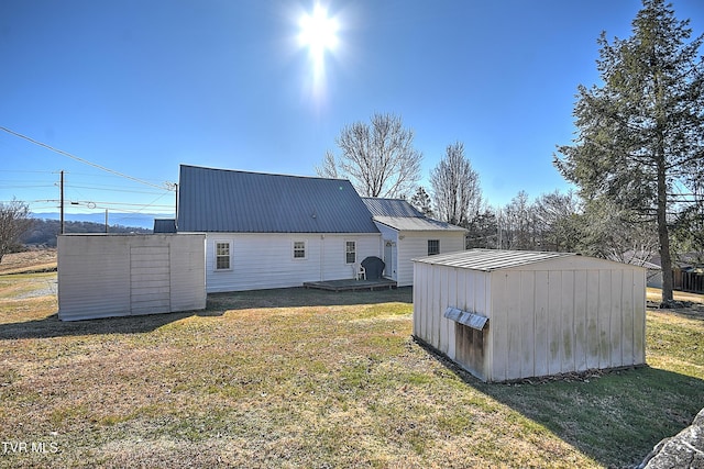 back of property featuring a storage shed and a lawn