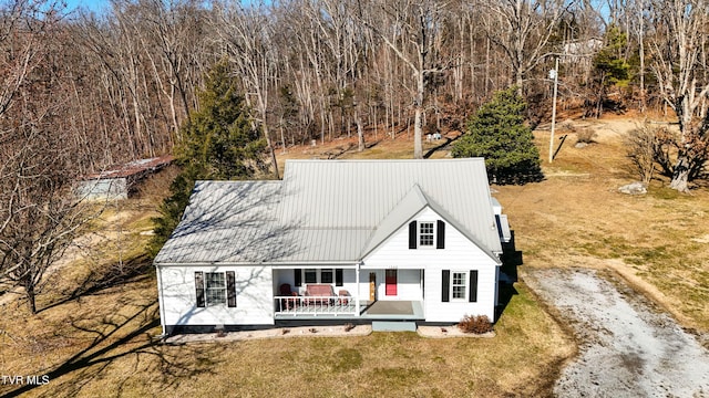 back of property featuring a yard and covered porch