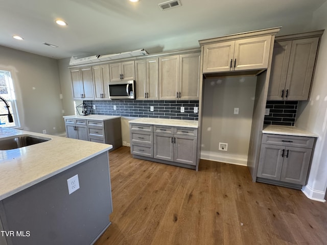 kitchen featuring sink, gray cabinets, tasteful backsplash, and dark hardwood / wood-style flooring