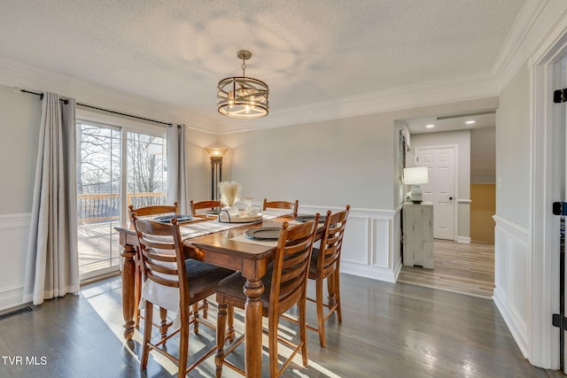 dining area with dark hardwood / wood-style flooring, crown molding, a chandelier, and a textured ceiling