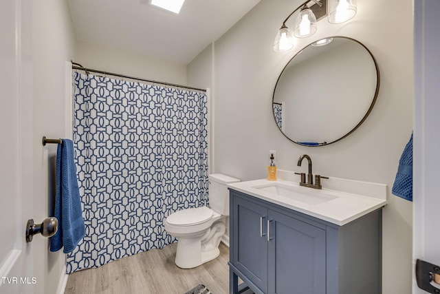 bathroom with wood-type flooring, vanity, and toilet