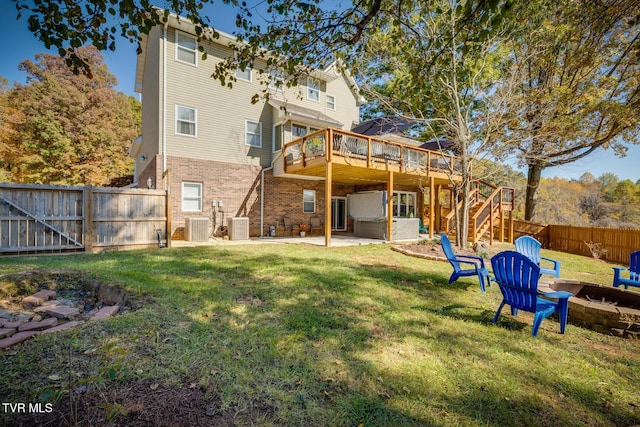 rear view of property featuring a jacuzzi, central AC unit, a deck, a fire pit, and a patio