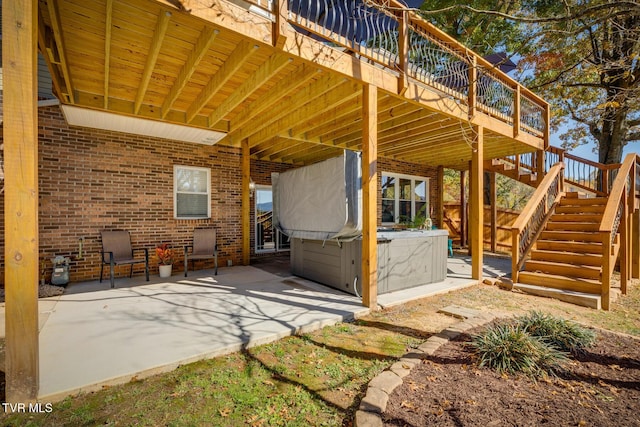 view of patio / terrace with a hot tub and a deck