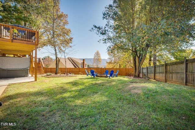 view of yard with a fire pit, a hot tub, and a deck