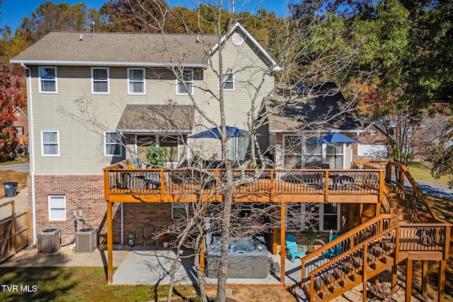 back of property with a wooden deck, a patio, and cooling unit