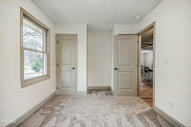 unfurnished bedroom with carpet floors and a textured ceiling