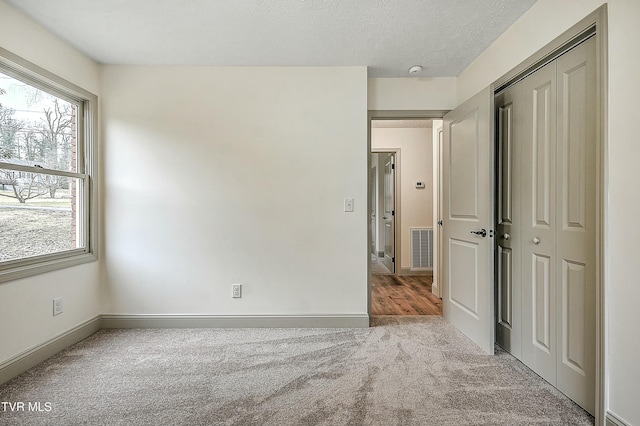 carpeted empty room with a textured ceiling