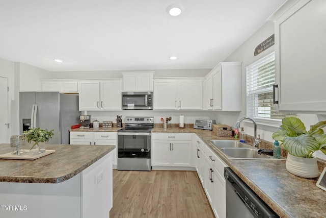 kitchen with white cabinetry, appliances with stainless steel finishes, light hardwood / wood-style floors, and sink