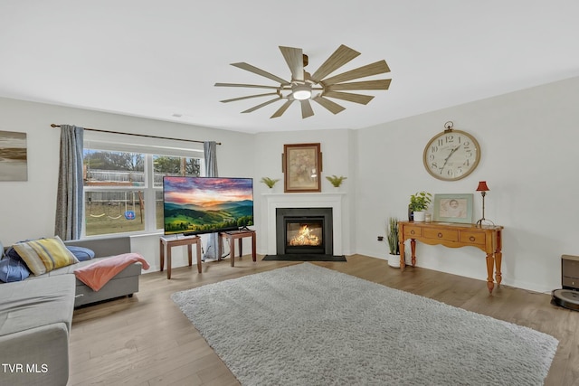 living room featuring ceiling fan and light hardwood / wood-style flooring