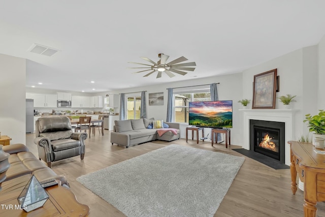 living room with ceiling fan and light hardwood / wood-style floors