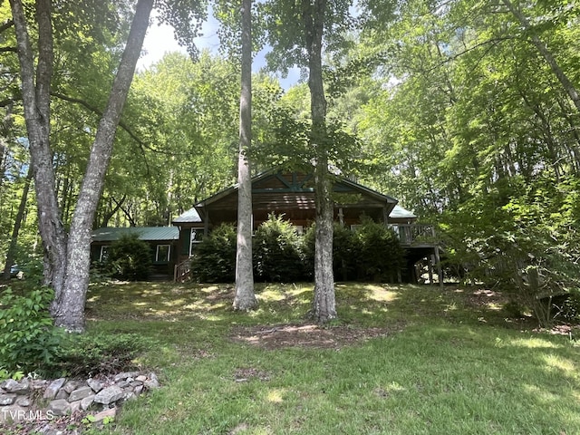 view of side of home featuring a deck and a lawn